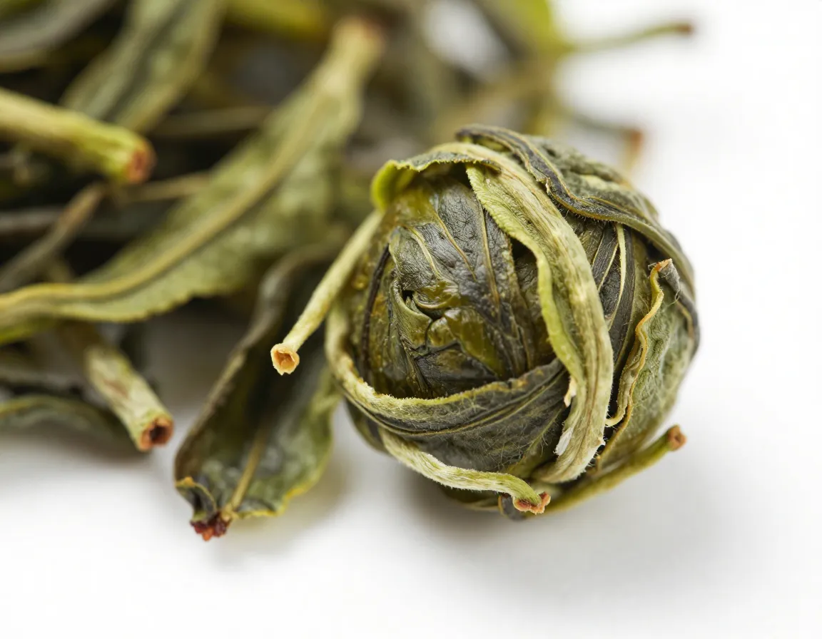 Macro photograph of unrolled jasmine tea pearl on white surface